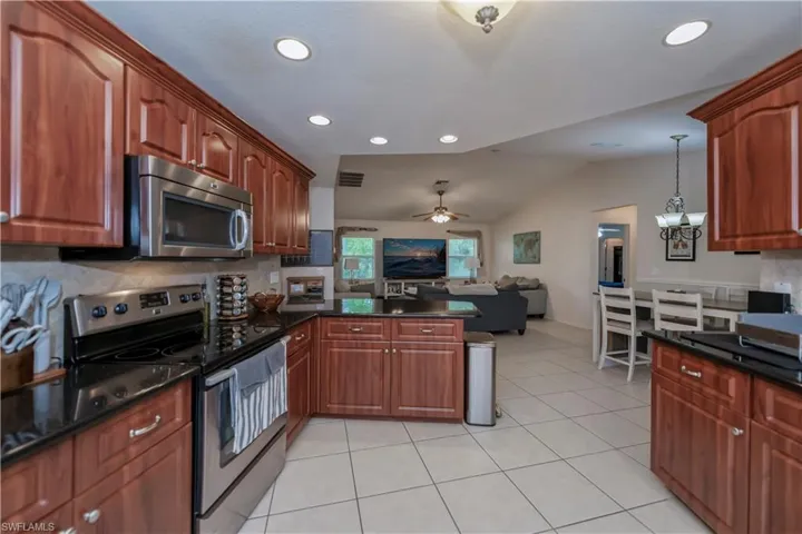 Kitchen with stainless steel appliances, vaulted ceiling, tasteful backsplash, and pendant lighting