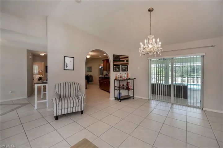 Tiled living room with a notable chandelier and vaulted ceiling