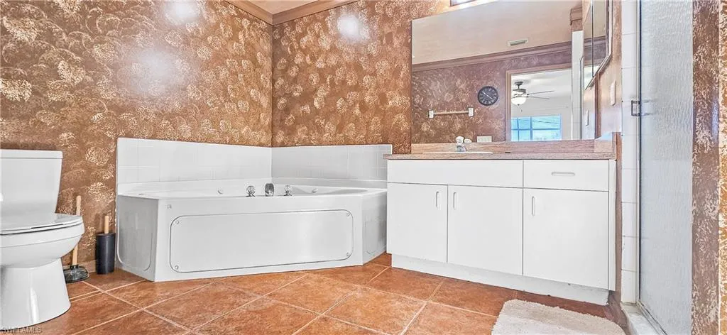 Bathroom featuring a bath, vanity, wallpapered walls, an enclosed shower, and light tile patterned floors
