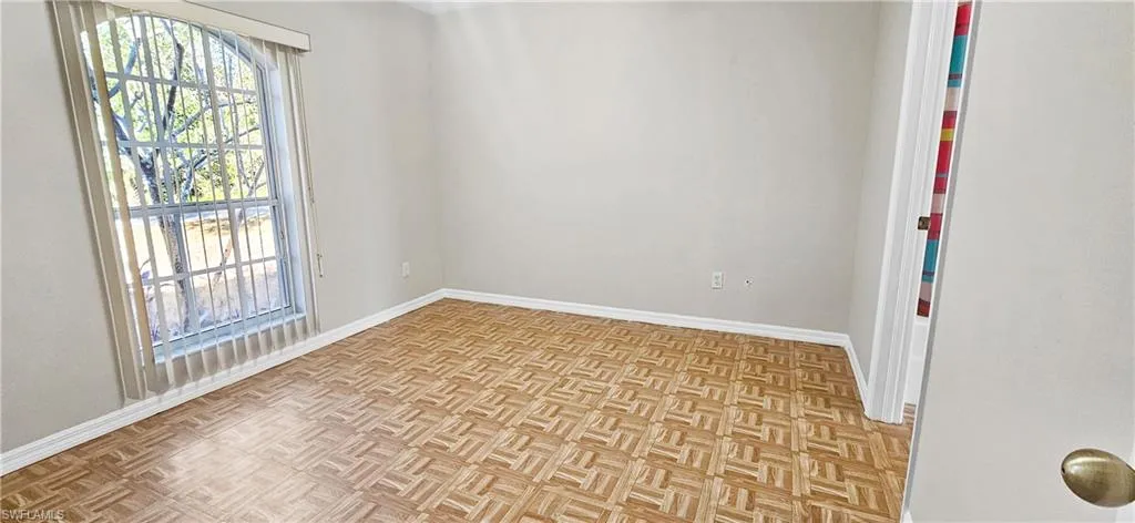 Unfurnished room with baseboards and parquet floors