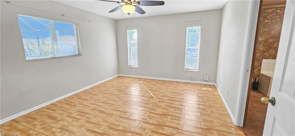 Unfurnished room with wood tiled floors and a ceiling fan