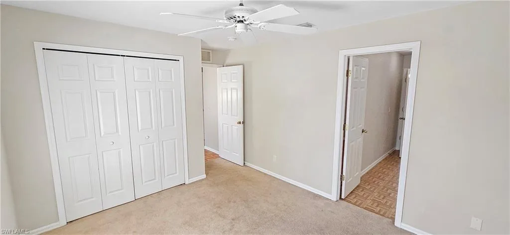 Unfurnished bedroom featuring a closet, a ceiling fan, and light carpet
