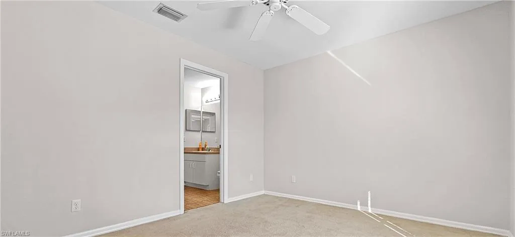 Empty room featuring light carpet and a ceiling fan