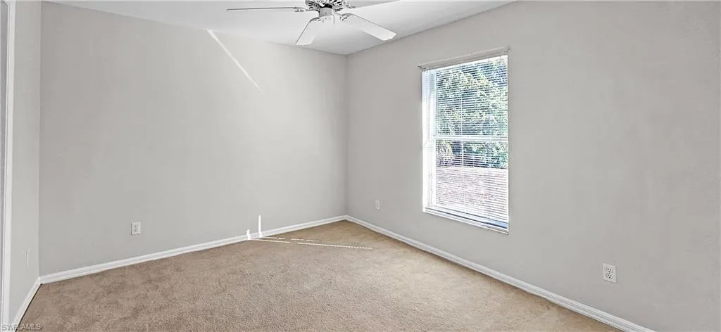 Unfurnished room with a ceiling fan and carpet flooring