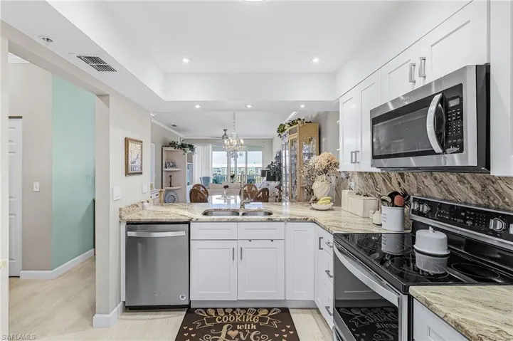 Beautifully updated kitchen w/stainless steel appliances, granite counter top and backsplash, perimeter and task down lighting, luxury vinyl plank flooring.