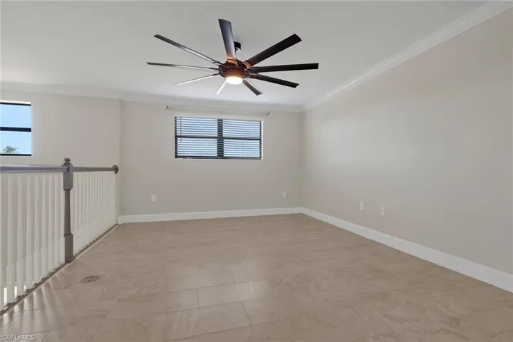 Loft with crown molding and ceiling fan