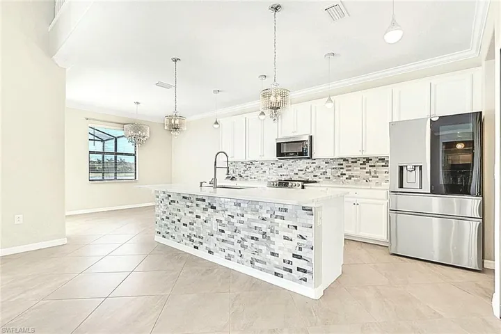 Amazing Kitchen featuring BEAUTIFUL upgraded Chandelier lighting, UPGRADED  crown molding, cabinets upgrade, stainless steel appliances, tasteful backsplash, and an island with sink. Also with Formal dining or eat-in kitchen.