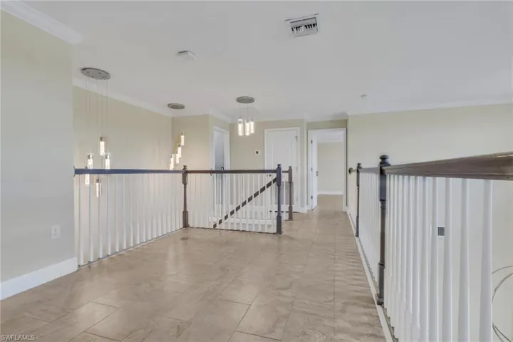 Hall with crown molding and an upstairs landing