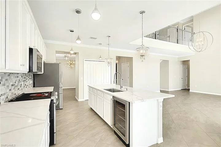 Amazing Kitchen featuring BEAUTIFUL upgraded Chandelier lighting, UPGRADED  crown molding, cabinets upgrade, stainless steel appliances, tasteful backsplash, and an island with sink. Also with Formal dining or eat-in kitchen and WINE COOLER