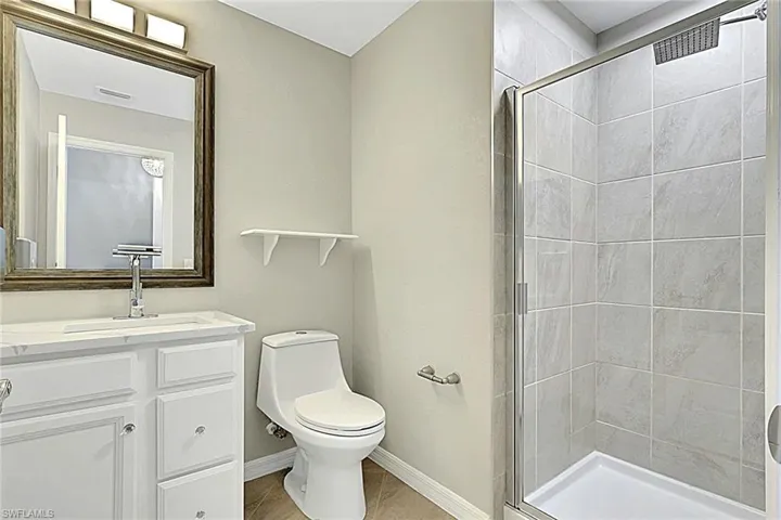 Full bath featuring a stall shower and vanity