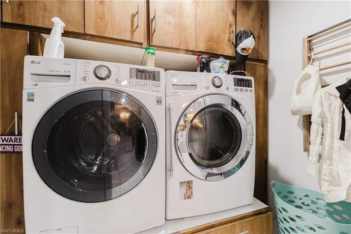 Laundry room featuring independent washer and dryer and cabinet space