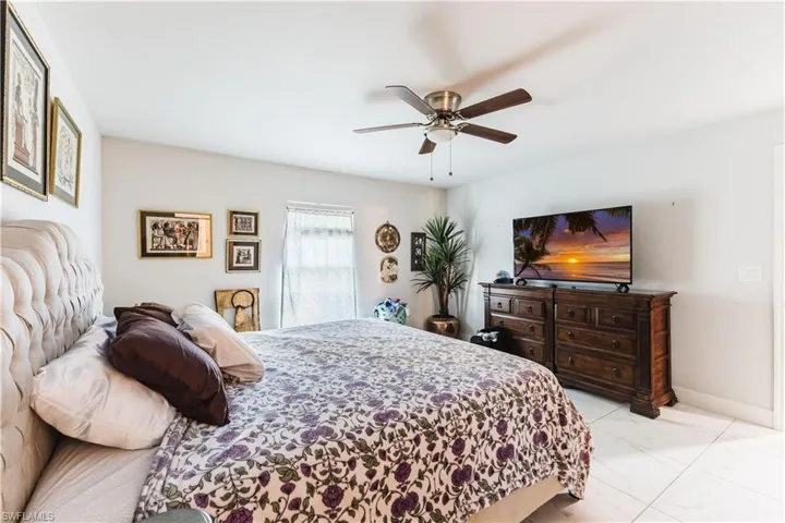 Bedroom with light marble finish flooring and a ceiling fan