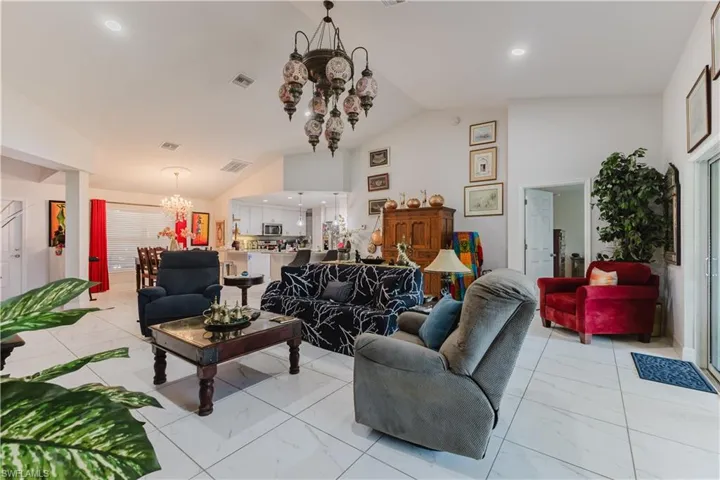 Living room featuring a chandelier, recessed lighting, and high vaulted ceiling