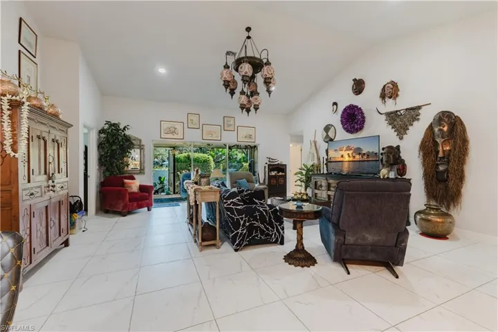 Living area with vaulted ceiling, a chandelier, and recessed lighting