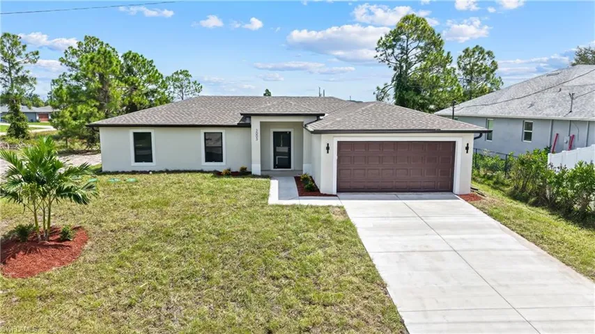 Contemporary stucco exterior with a durable shingle roof, integrated two-car garage, and a concrete driveway