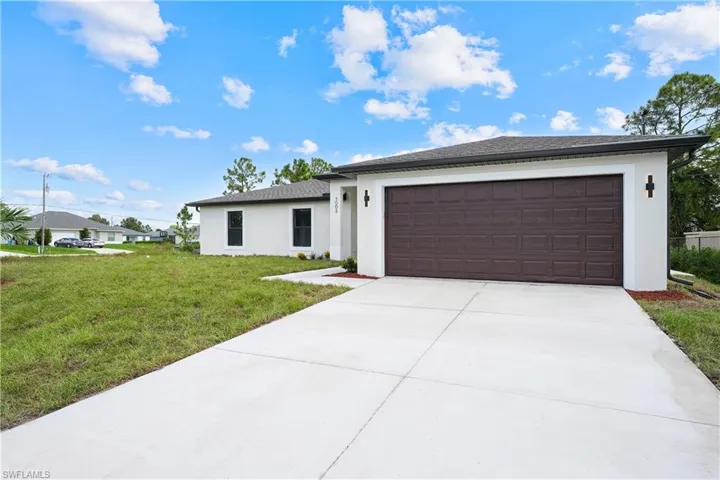 Contemporary exterior with a dark brown garage door, white stucco finish, and exterior sconces
