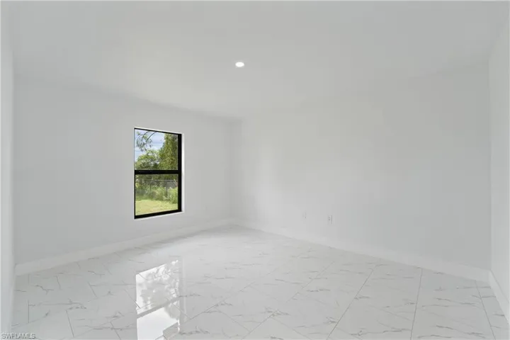 Recessed lighting, tile flooring, white walls, and a single window