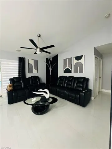 Living area featuring a ceiling fan and baseboards