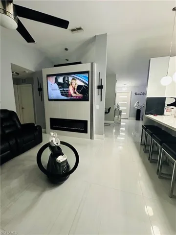 Cinema room with light tile patterned floors, a fireplace, and visible vents