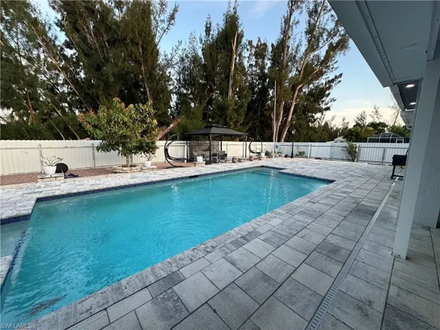 View of swimming pool with a gazebo, a patio area, a fenced backyard, and a fenced in pool