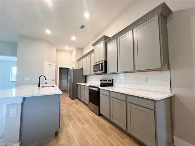 Bathroom with a walk in closet, double vanity, wood tiled floors, and a shower with shower door