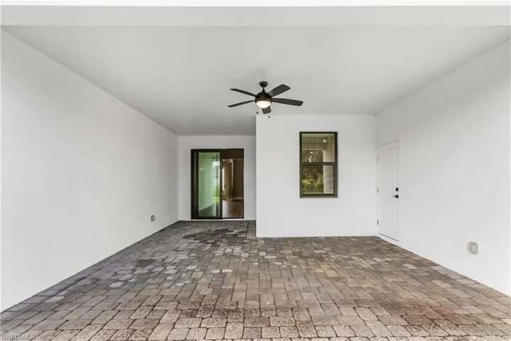 Rear view of house with a lawn, a patio area, a ceiling fan, and stucco siding