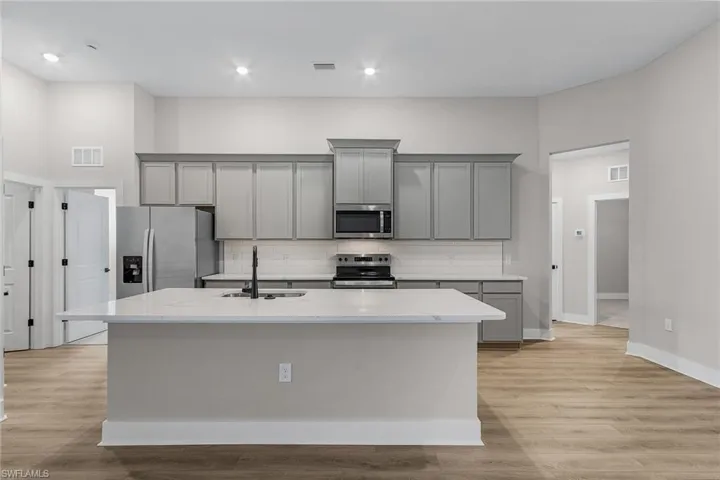 Prairie-style home with a front yard, decorative driveway, stucco siding, and a garage