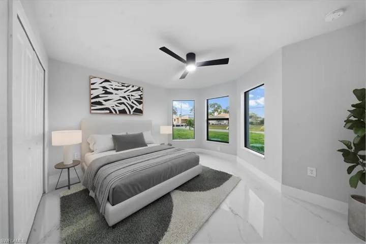 Bedroom with marble finish floors, a ceiling fan, and a closet