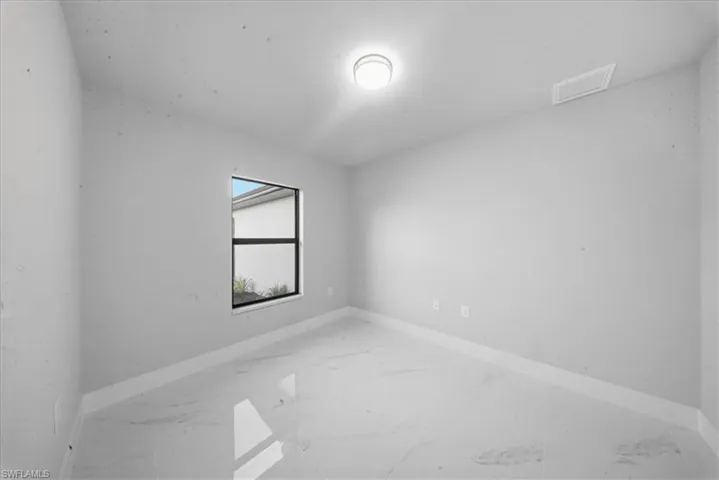 Empty room featuring light marble finish floors