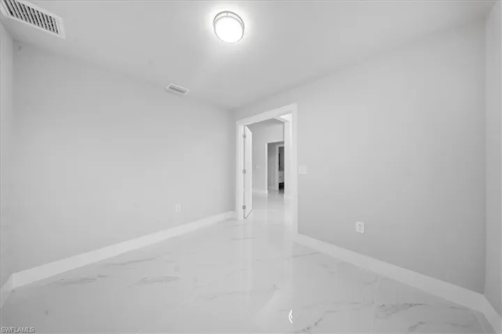 Spare room with light marble finish flooring and baseboards