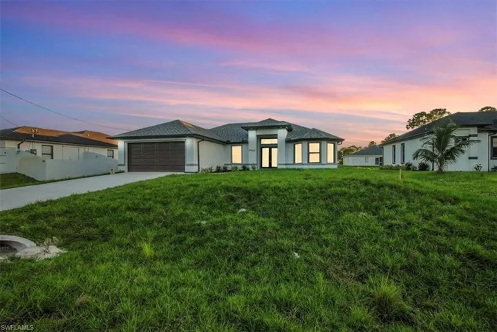 Prairie-style home with a yard, driveway, and a garage