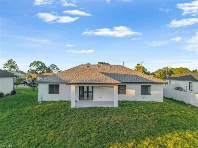 Back of house featuring stucco siding, a patio, and roof with shingles