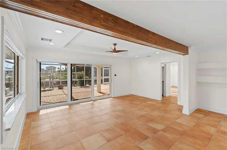Spare room featuring ceiling fan, light tile patterned flooring, a raised ceiling, and ornamental molding