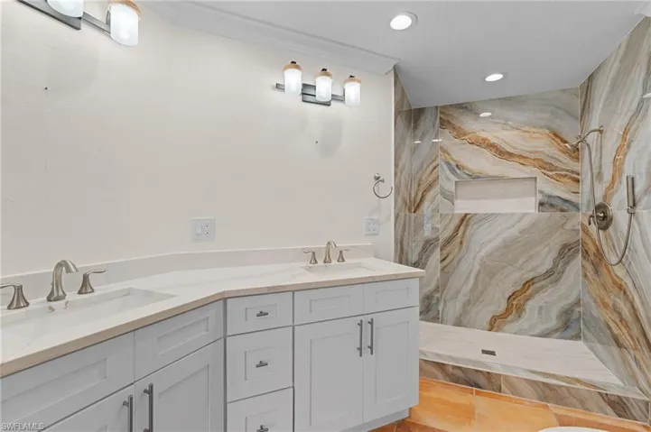 Bathroom with a shower, vanity, tile patterned floors, and crown molding