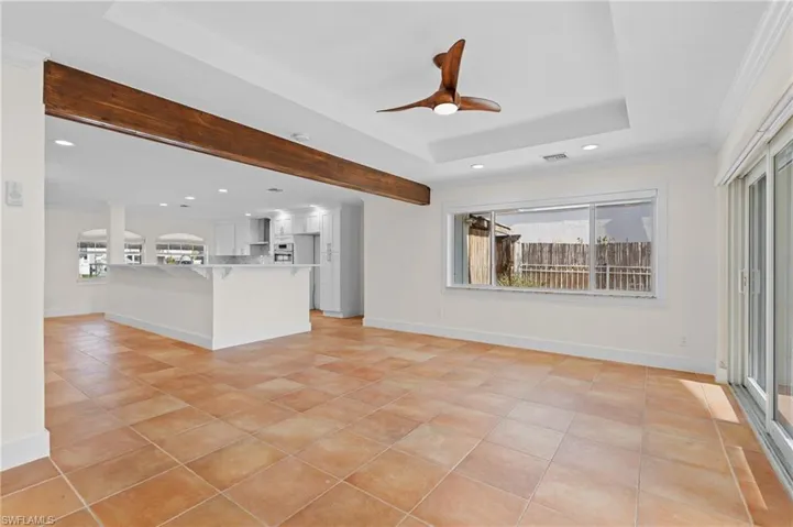 Unfurnished living room with crown molding, ceiling fan, a healthy amount of sunlight, and light tile patterned flooring