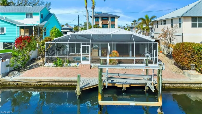 Rear view of house with a lanai and a water view