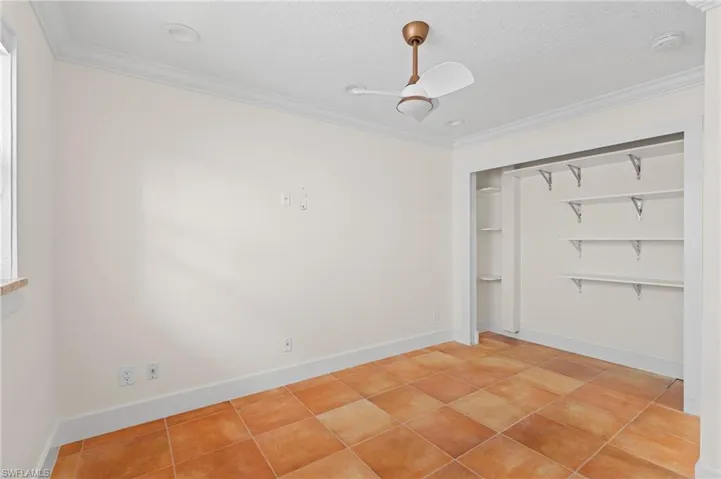 Unfurnished bedroom featuring ceiling fan, ornamental molding, a textured ceiling, and a closet