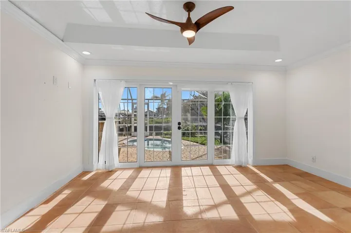 Tiled spare room with ceiling fan and ornamental molding