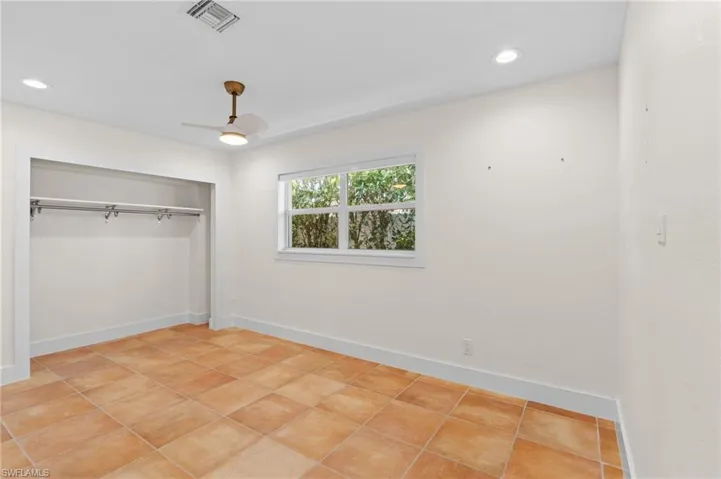 Unfurnished bedroom with light tile patterned floors, a closet, and ceiling fan