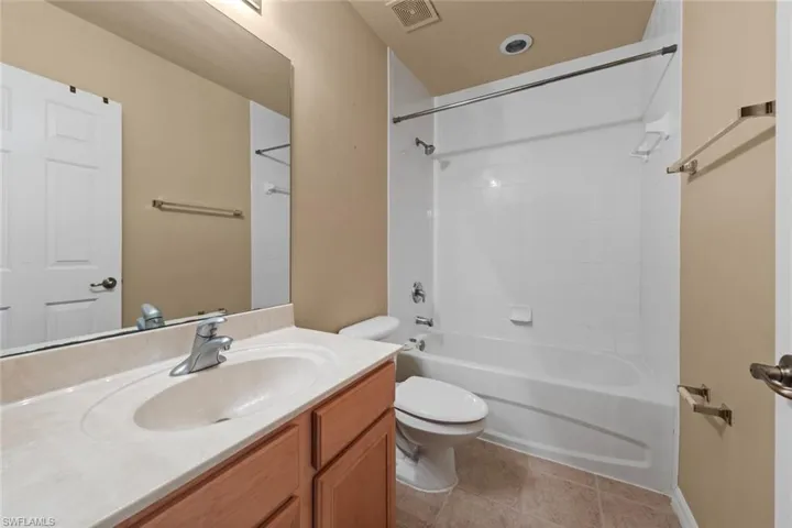 Full bathroom with tile patterned floors, vanity, toilet, and shower / washtub combination