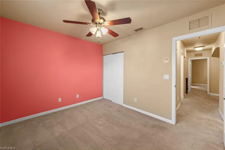 Unfurnished bedroom with light carpet, a closet, and ceiling fan