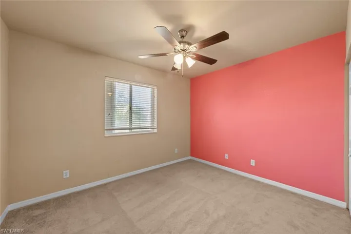Carpeted empty room with ceiling fan