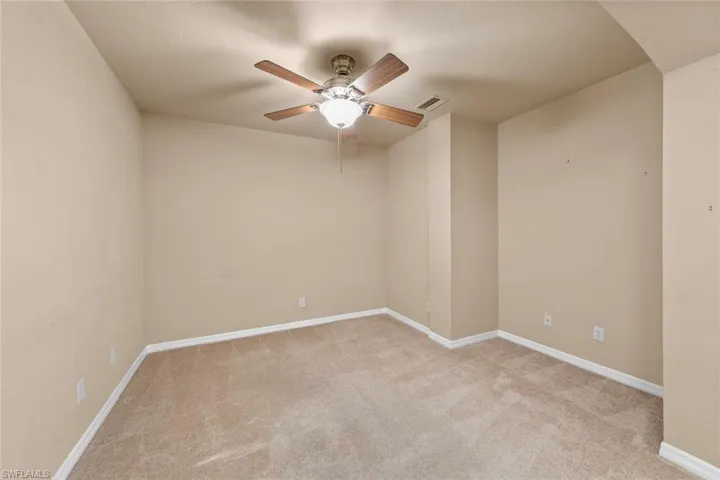 Spare room featuring light carpet and ceiling fan