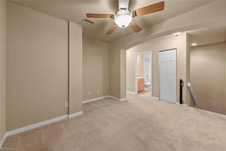 Spare room featuring ceiling fan and light colored carpet