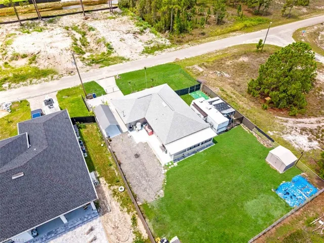 Spacious property featuring a large, manicured lawn, a detached storage shed, and a covered patio area