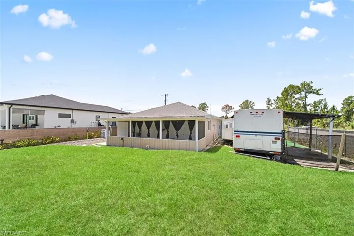 Expansive lawn area featuring a screened porch with dark privacy screens