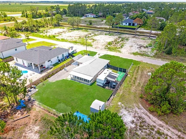 Expansive green lawn with a white storage shed