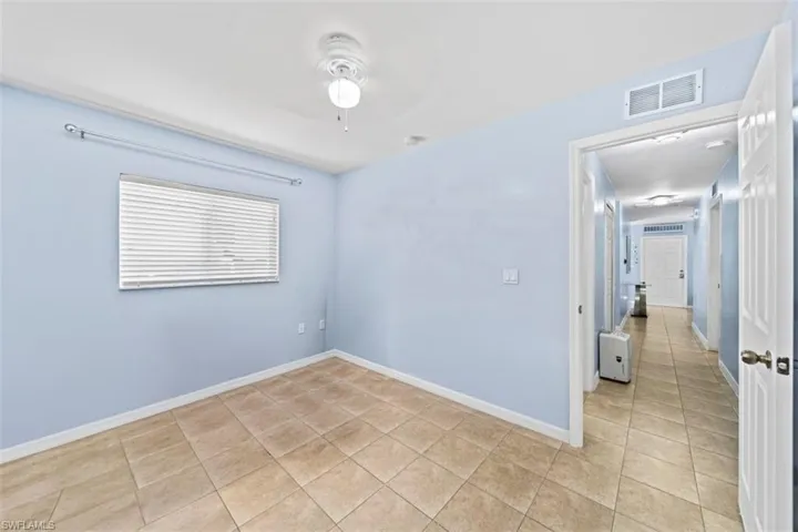 Spacious room featuring light blue walls and tile flooring