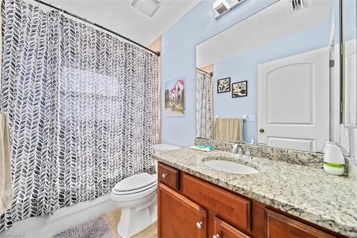 Bathroom featuring a vanity with an integrated sink, a speckled countertop, and wood-finish cabinetry