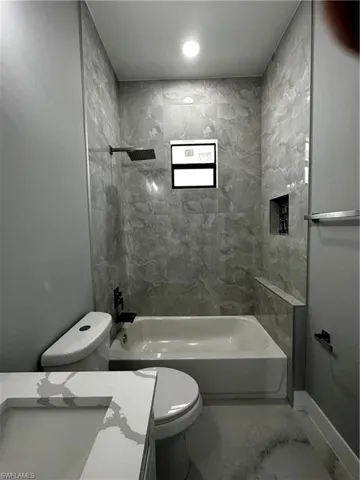 Custom tub in shower with tiled wall and niche